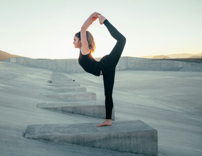 Photo by Wesley Tingey shallow focus photo of woman in black sleeveless shirt doing yoga