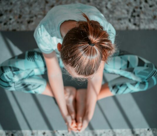 필라테스 동작으로 운동 중 체형 교정 girl in teal t-shirt lying on white and black stripe bed
