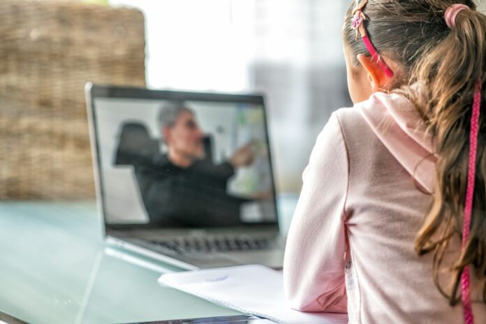 Photo by Giovanni Gagliardi woman in pink long sleeve shirt sitting in front of macbook pro
