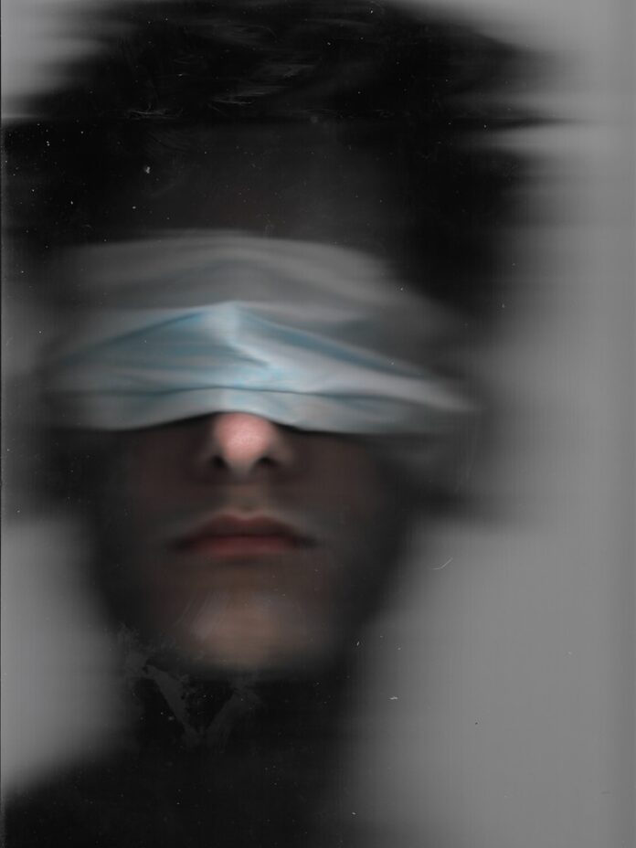 Photo by Manuel bonadeo a man with a blindfold over his eyes