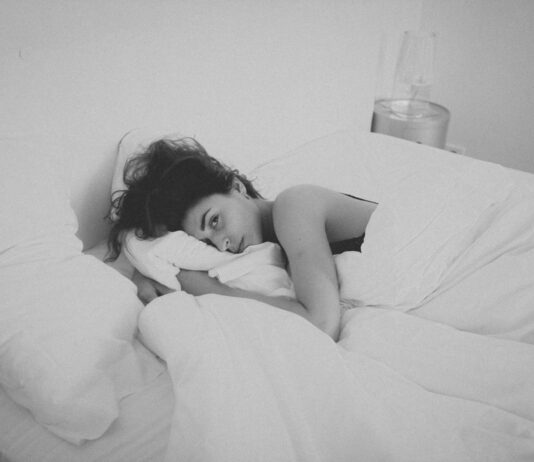 “하루 종일 피곤한데 커피도 소용없다?” — 만성 피로증후군 의심 신호 woman lying on bed covered by white blanket