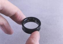 AI 기반 건강 관리, 개인 맞춤형 솔루션으로 헬스케어의 미래를 연다 Fingers hold a black smart ring with circuits visible.