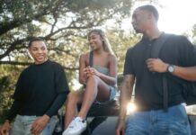 “움직이는 직장인, 건강이 따라온다”… 유연한 근무와 셀프케어 습관이 화제 Three friends talking outdoors on a sunny day.