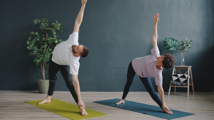 Couple practicing yoga in a modern room.