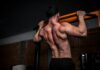“근육, 건강과 삶의 질을 지키는 데 중요한 이유와 일상 속 실천법” topless man in black shorts holding orange bar