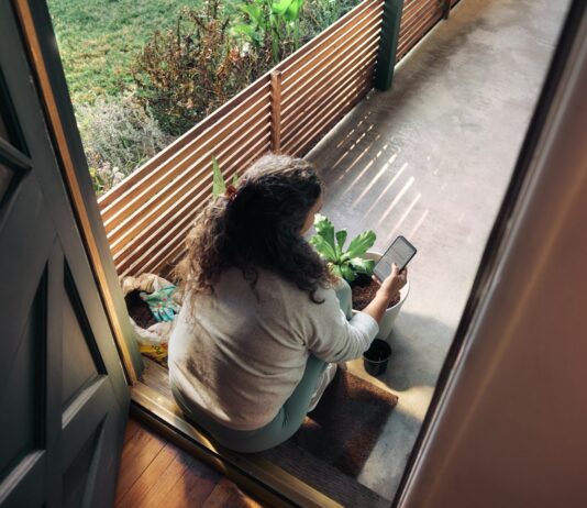 만성피로, 일상 속에서 벗어나는 새로운 습관 찾기 Woman sitting on balcony with smartphone